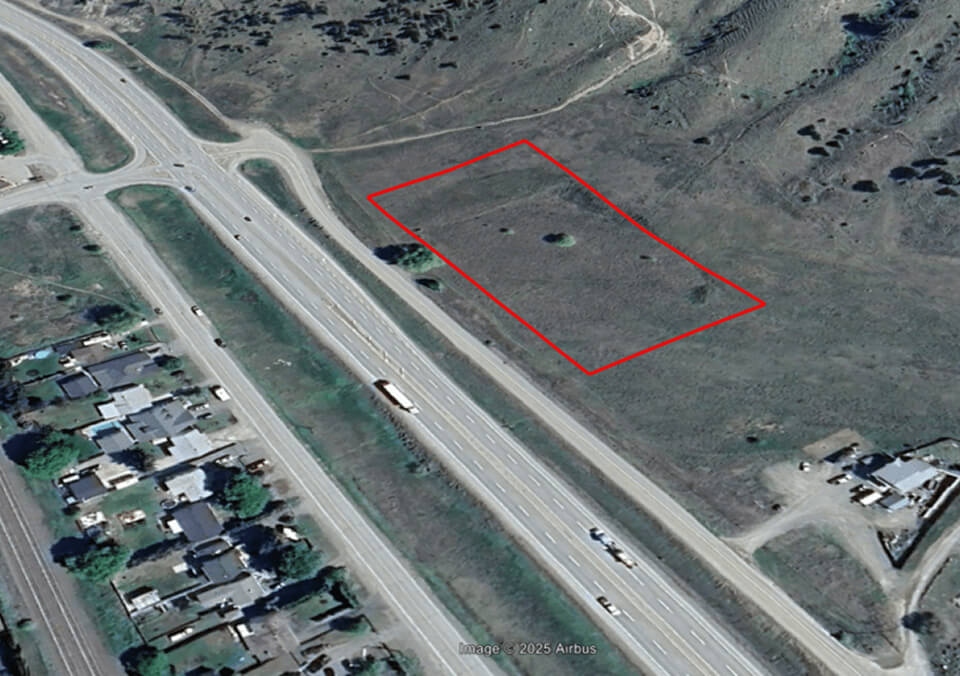 Aerial view of proposed Kamloops Search and Rescue site location outlined near highway with surrounding terrain and access roads